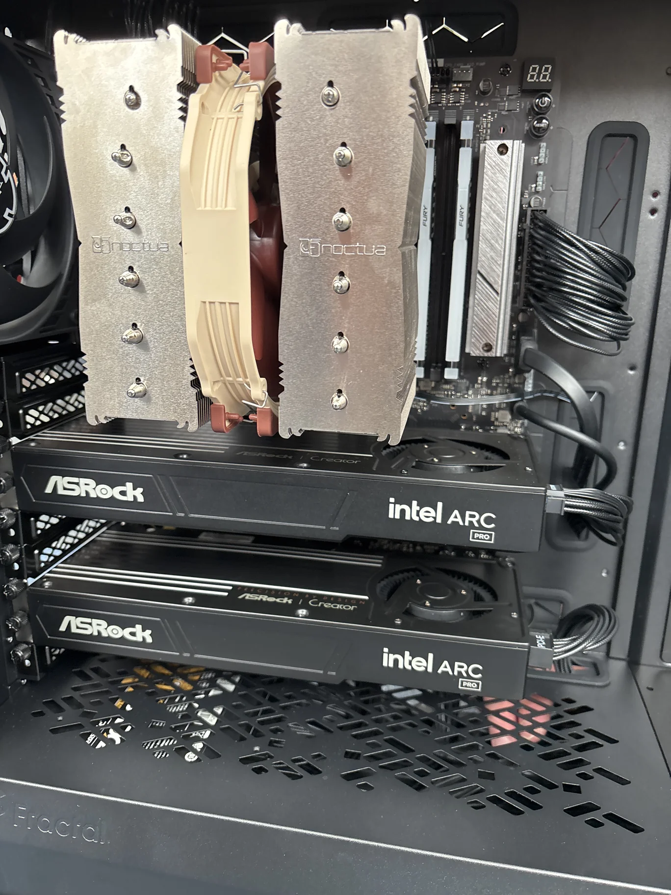 Inside the computer, with two ASRock Intel Arc Pro cards and a large Noctua cooler above them